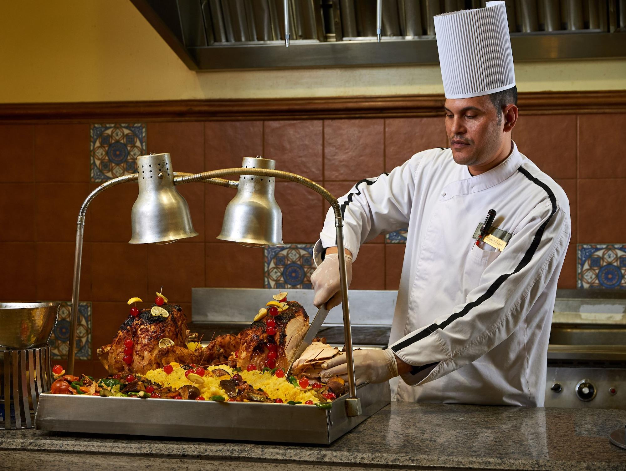 Mosaique Beach Resort Taba Heights Exterior photo A chef carving a roast